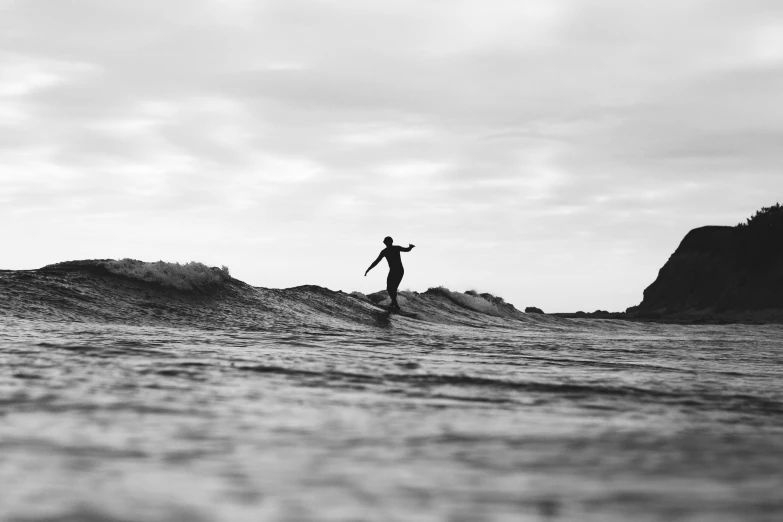 a man riding a wave on top of a surfboard, a black and white photo, by Kristian Zahrtmann, unsplash contest winner, standing elegantly, on the coast, sup, currents