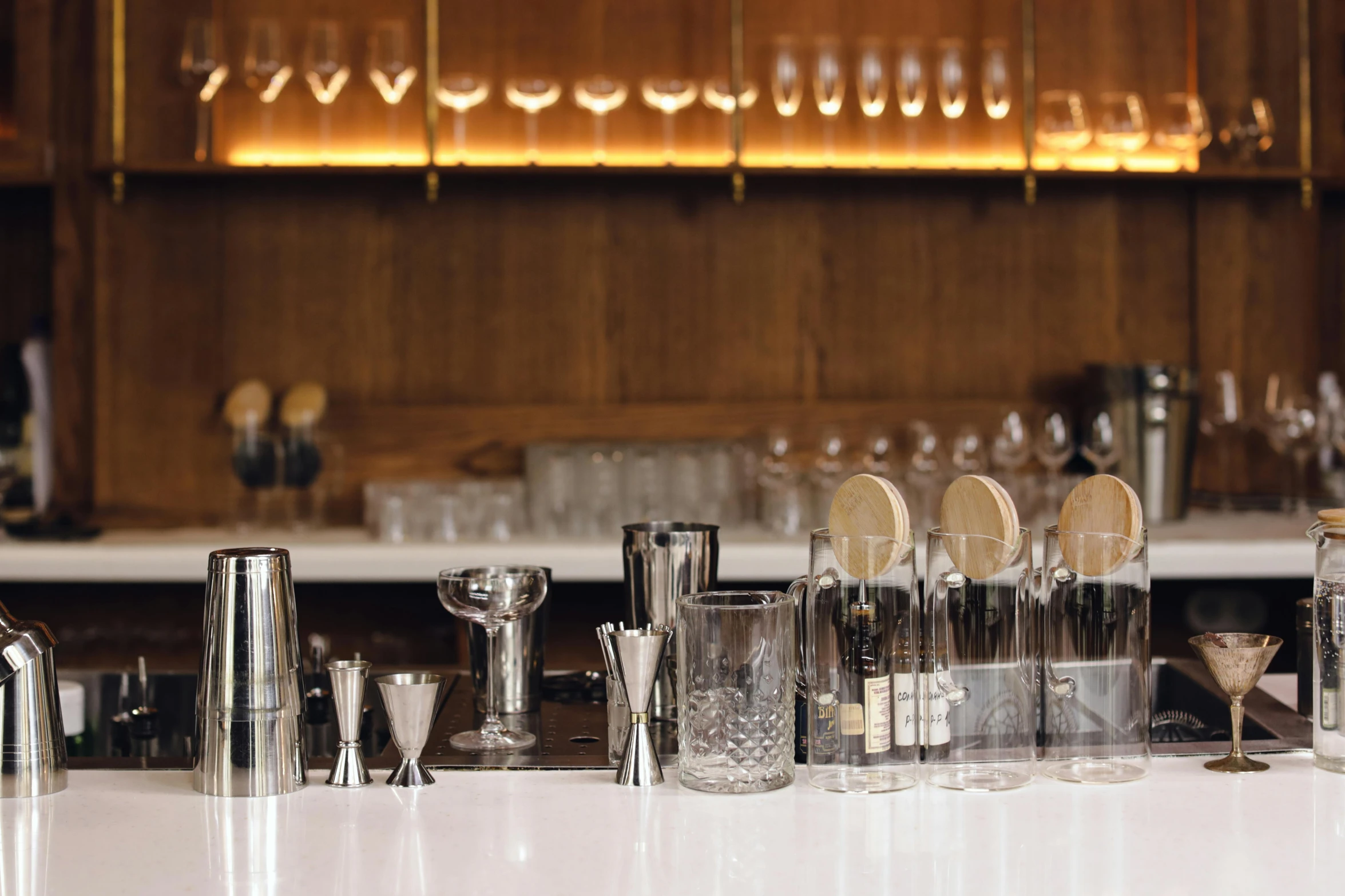 a group of glasses sitting on a counter near bottles and shakers