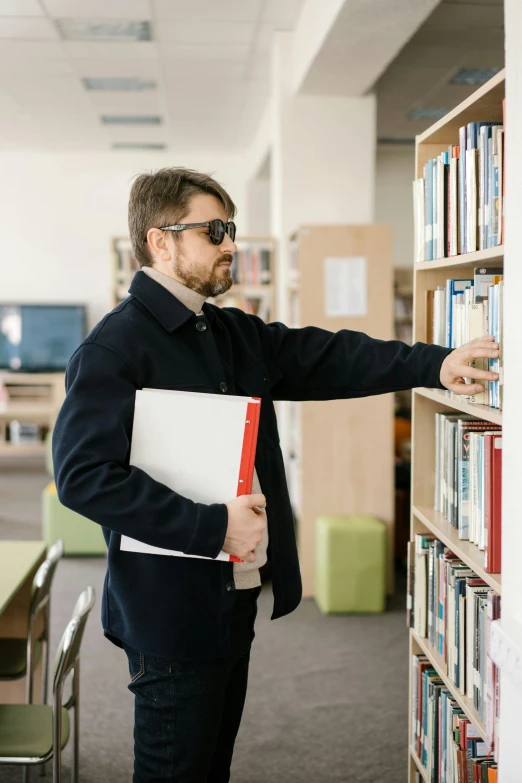 a man standing next to a book shelf in a library, trending on reddit, security agent, he is at college, dramedy, thumbnail