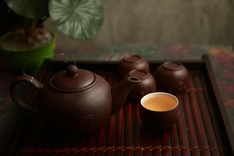 a tea pot sitting on top of a tray next to a cup of tea, inspired by Cao Buxing, trending on cg society, group photo, brown, thumbnail