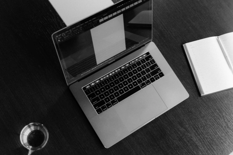 a laptop computer sitting on top of a wooden table, by Romain brook, pexels, black white, square, apple design, screenwriter