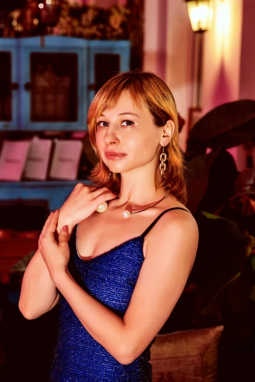 a woman in a blue dress posing for a picture, an album cover, inspired by Leila Faithfull, reddit, bokeh in the background only, anna nikonova aka newmilky, golden time, very very low quality picture