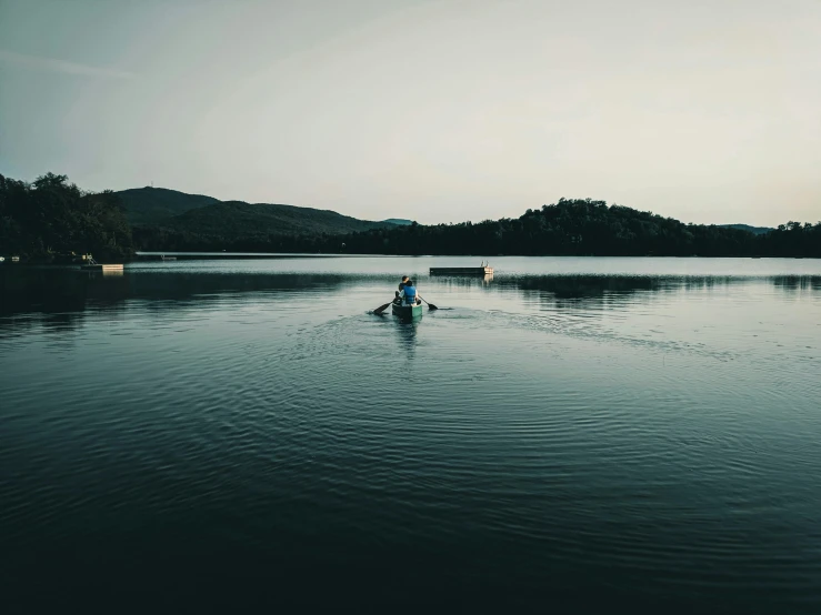 a couple of people in a small boat on a lake, unsplash contest winner, hurufiyya, trending on vsco, low quality photo, floating. greenish blue, late evening