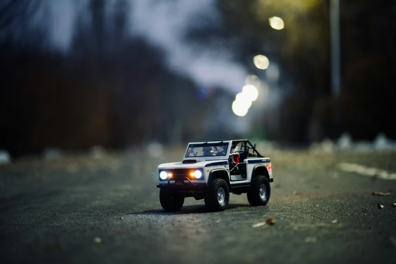 a small toy jeep is driving on the street