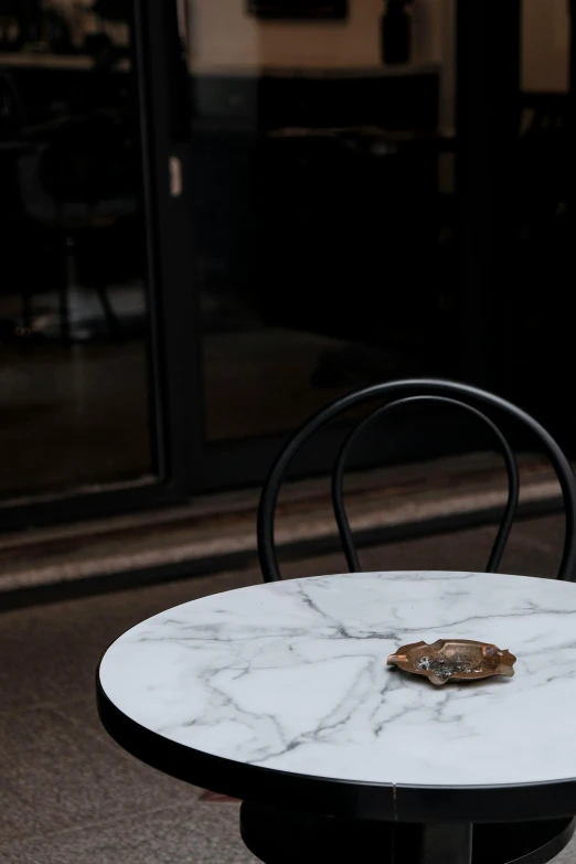 a table with two donuts on top of it, by Thomas Wijck, trending on unsplash, renaissance, metal hard surfaces, black chair, white marble, cafe for mice