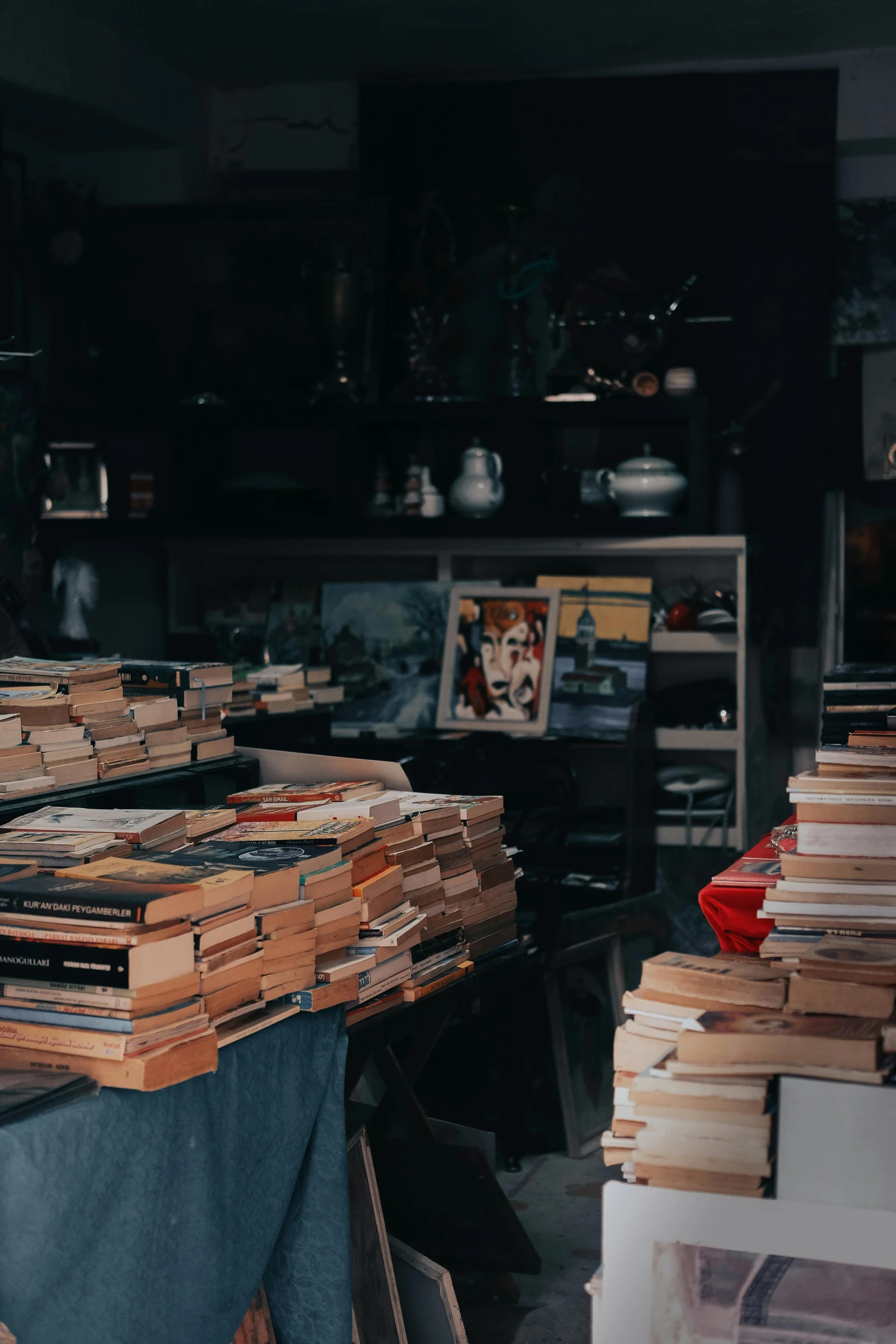 a pile of books sitting on top of a table, trending on unsplash, maximalism, an empty backroom at night, in a cluttered lab, gif, vintage photo