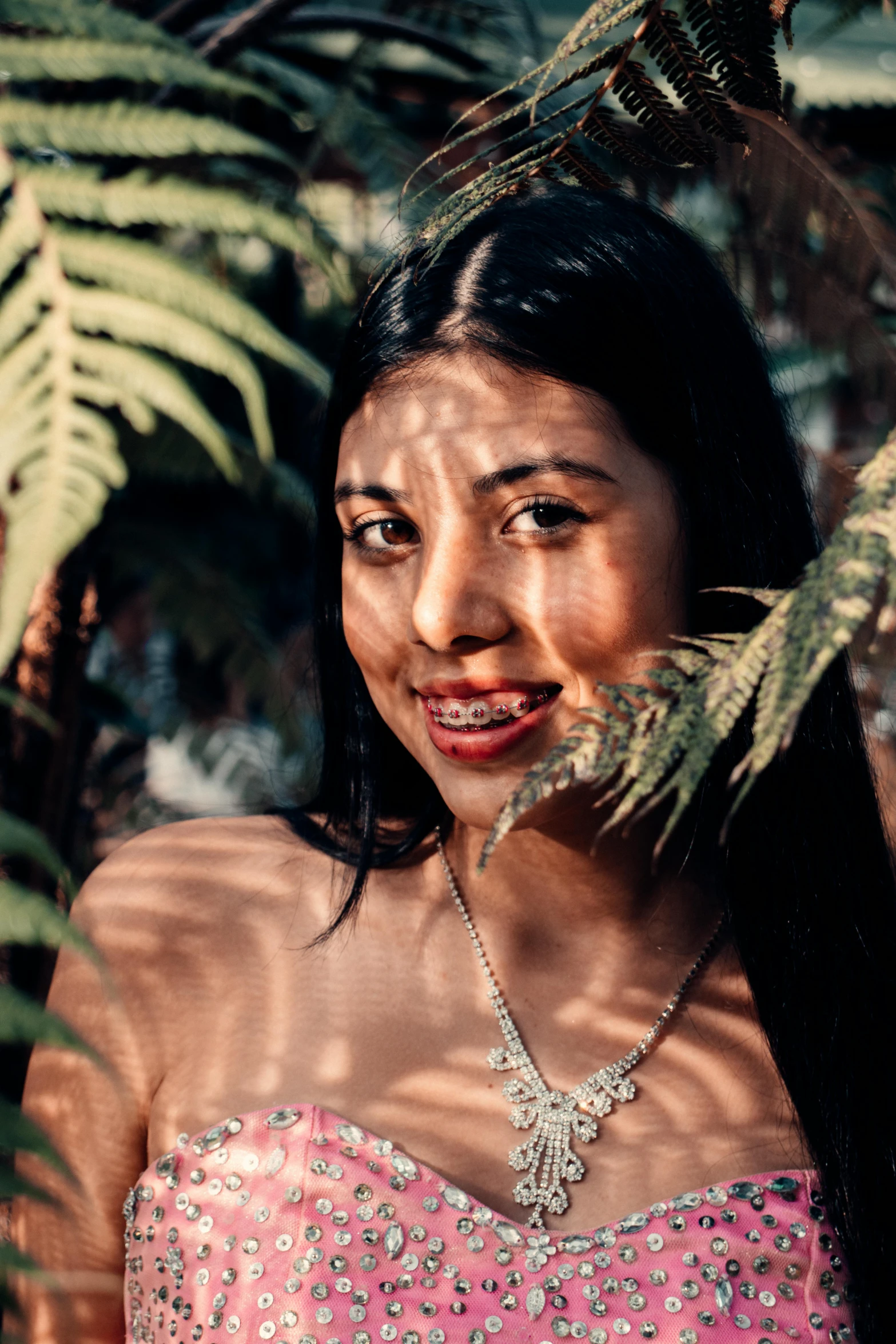 a woman in a pink dress posing for a picture, an album cover, inspired by Elsa Bleda, pexels contest winner, indian girl with brown skin, lianas, smiling seductively, peruvian looking