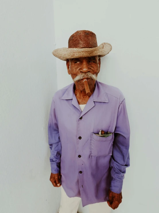 a man wearing a purple shirt and a straw hat, by Alejandro Obregón, thawan duchanee, oldman with mustach, 90's color photo, dressed in a worn