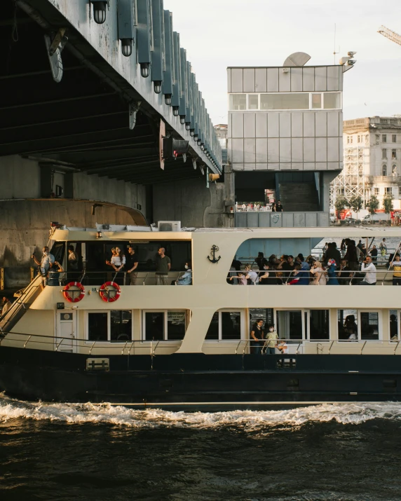 a large boat traveling down a river next to a bridge, full of people, non-binary, moscow, big windows