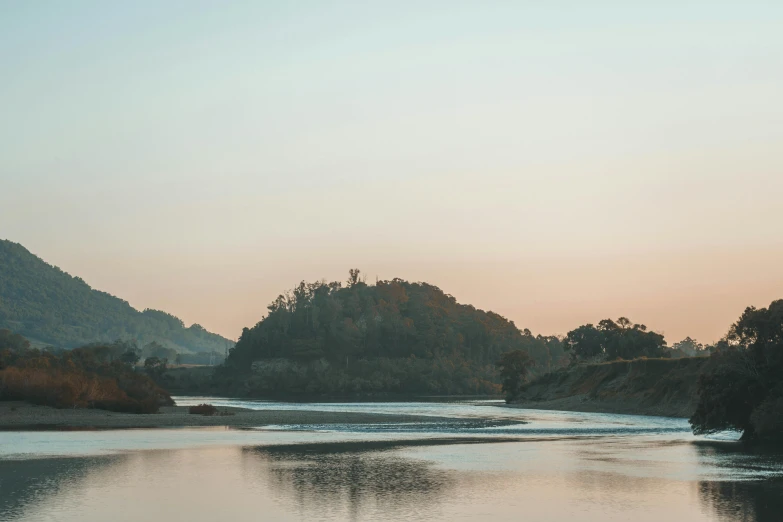 a body of water with mountains in the background, a picture, unsplash contest winner, romanticism, guwahati, river and trees and hills, golden hour 8k, faded glow