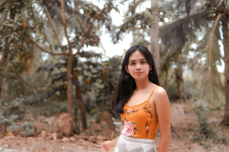 a woman standing in the middle of a forest, a portrait, by Robbie Trevino, pexels contest winner, wearing a camisole and shorts, batik, 18 years old, background image