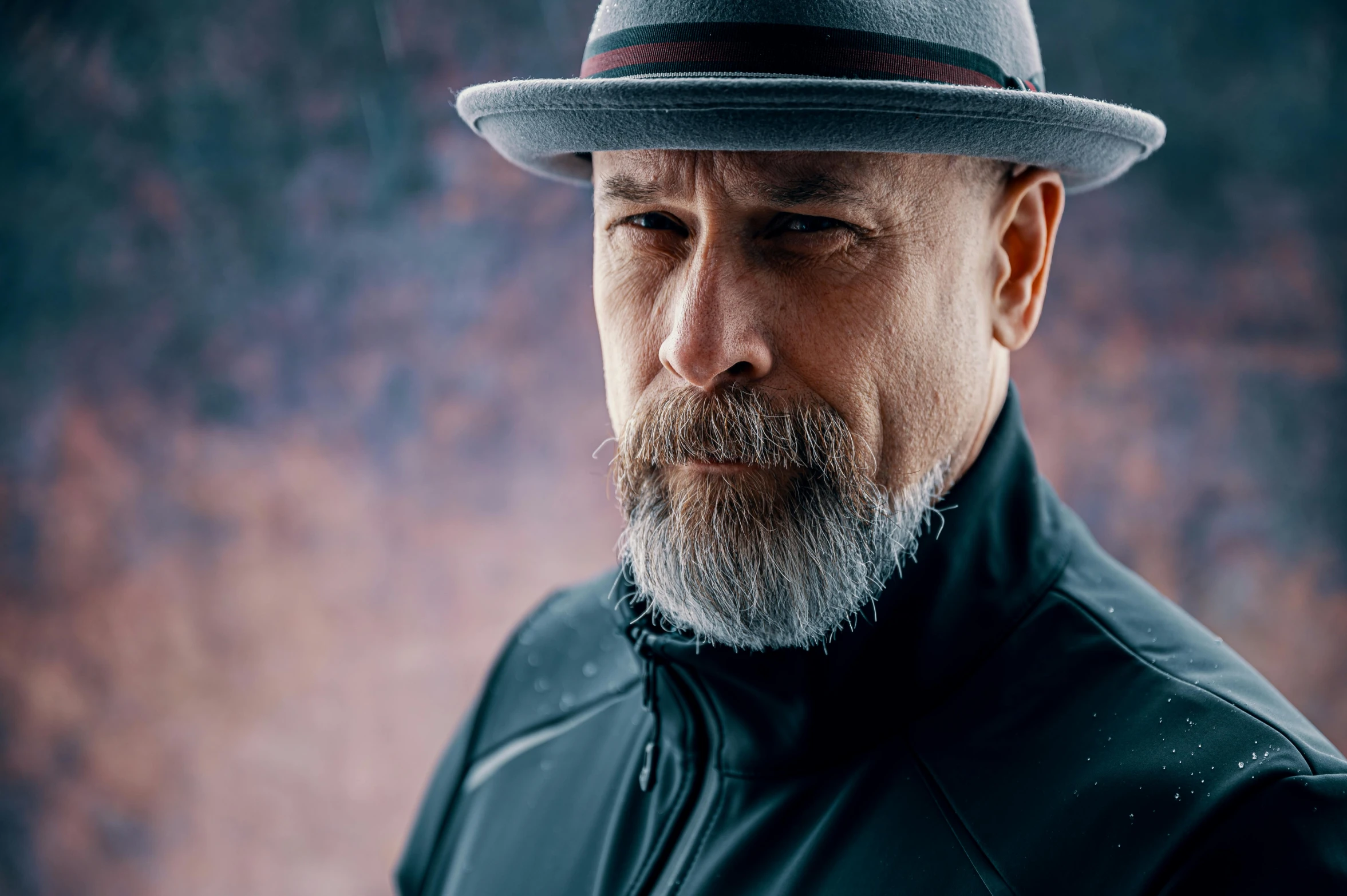 man with grey beard wearing hat and jacket