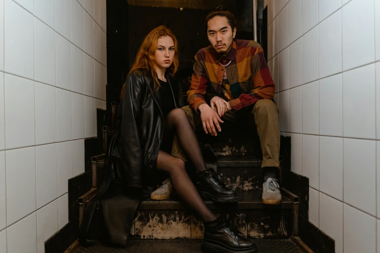a couple of people that are sitting on some stairs, a portrait, pexels contest winner, antipodeans, looks like a mix of grimes, leather clothing and boots, sydney sweeney, studio photo