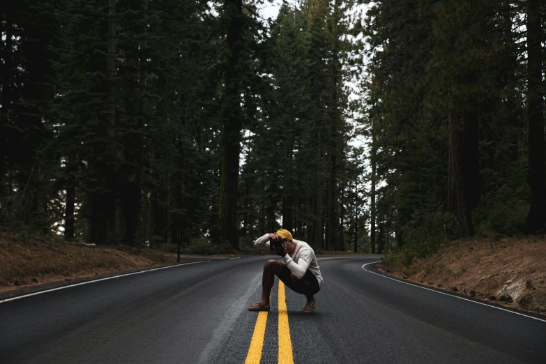 man with knee ces crouching down on the road