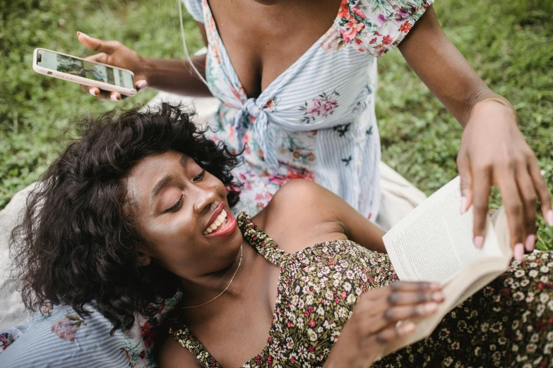 a woman laying on the ground while holding a book