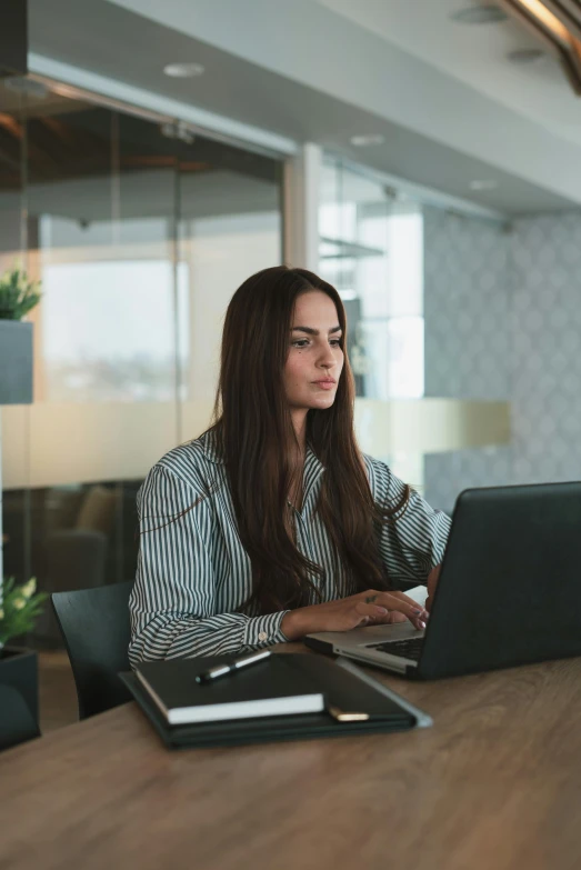 a woman sitting at a table working on a laptop, ceo, developers, day time, 2019 trending photo