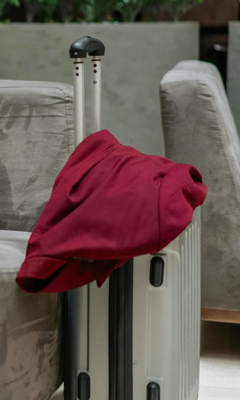 luggage bag in front of couch with red blanket