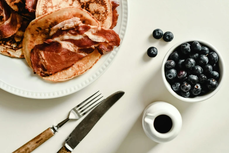 a white plate topped with fruit next to a fork and knife