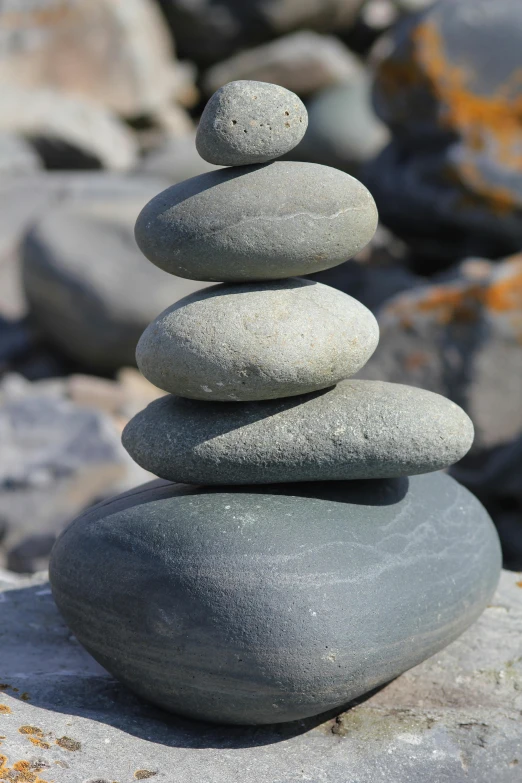 a stack of rocks sitting on top of a pile of rocks, inspired by Andy Goldsworthy, grey cobble stones, beach setting, tai chi, spire