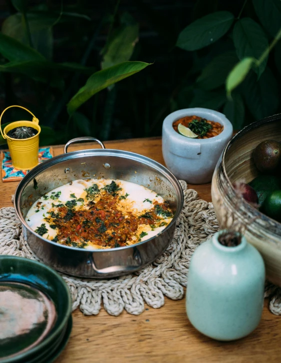 a wooden table topped with bowls of food, dau-al-set, in a jungle environment, enamel, recipe, thumbnail