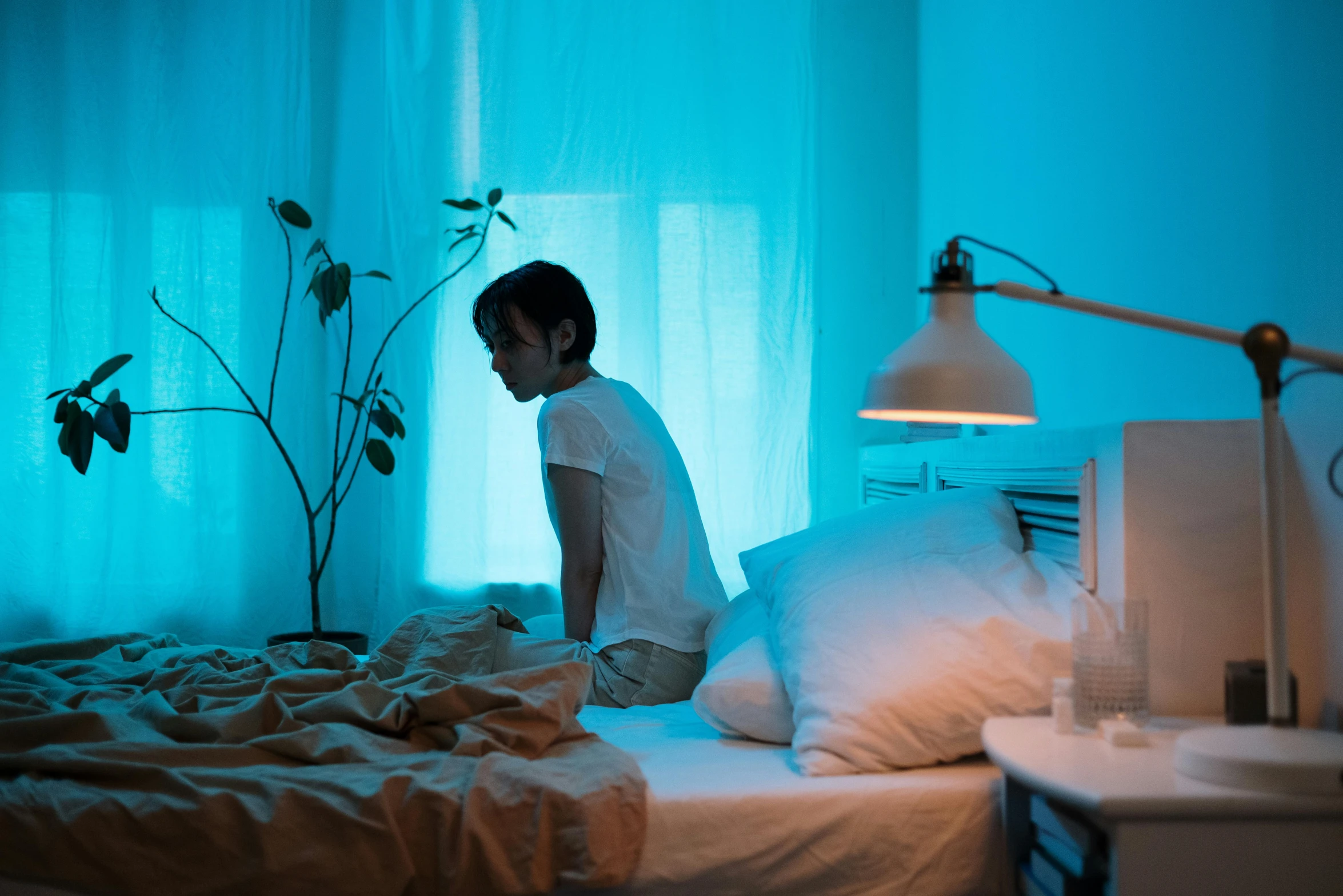 a  sitting on a bed in front of a window