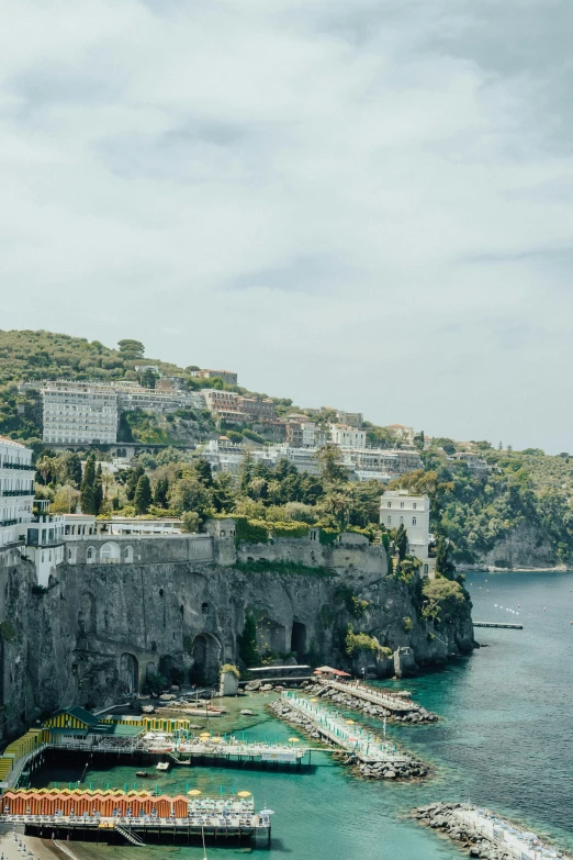 a large body of water next to a cliff, a matte painting, by Patrick Pietropoli, pexels contest winner, renaissance, naples, conde nast traveler photo, waterfront houses, lush surroundings