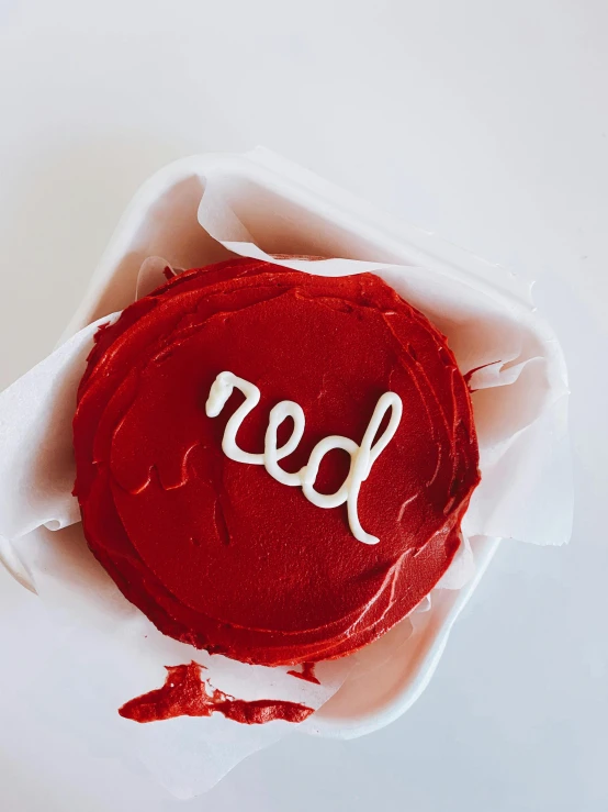 a red cake sitting on top of a white plate, red writing, trending on vsco, 🐿🍸🍋, real details