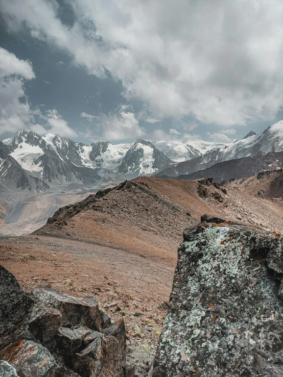 mountains and rocks on a cloudy day with some snow