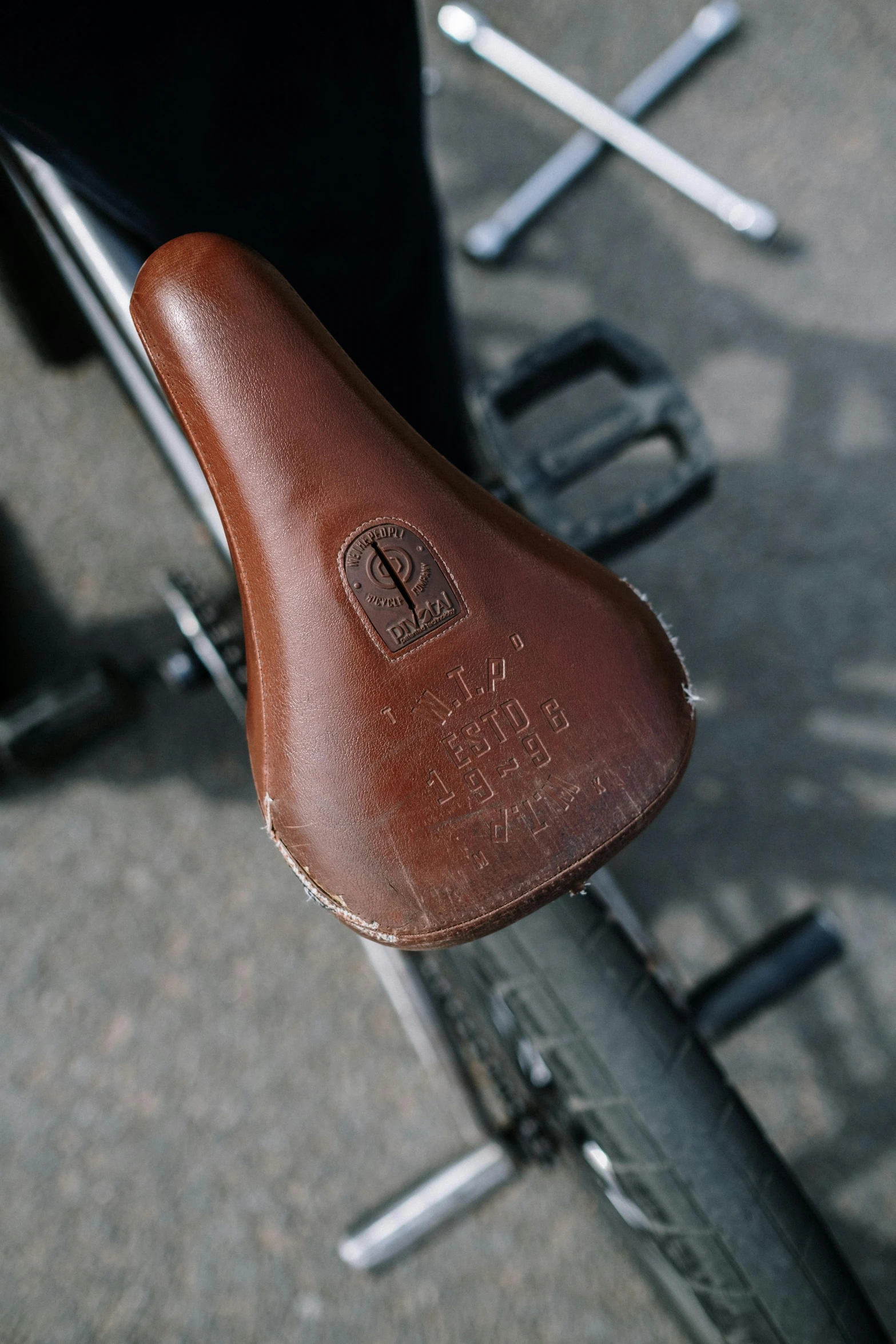 a close up of a saddle on a bike, by David Simpson, unsplash, etched inscriptions, sealed since 1989, soft rubber, vintage inspired