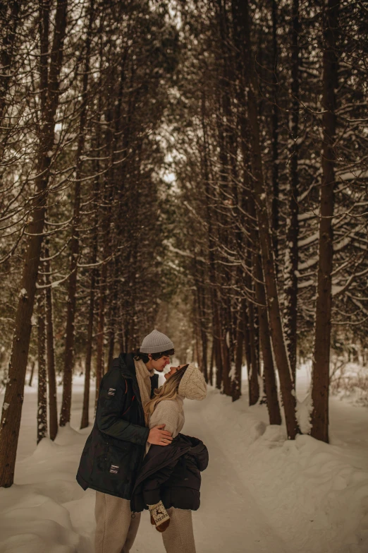 a man and woman standing next to each other in the snow, a picture, by Kristin Nelson, unsplash contest winner, tall large trees, kissing each other, sitting under a tree, lying on the woods path