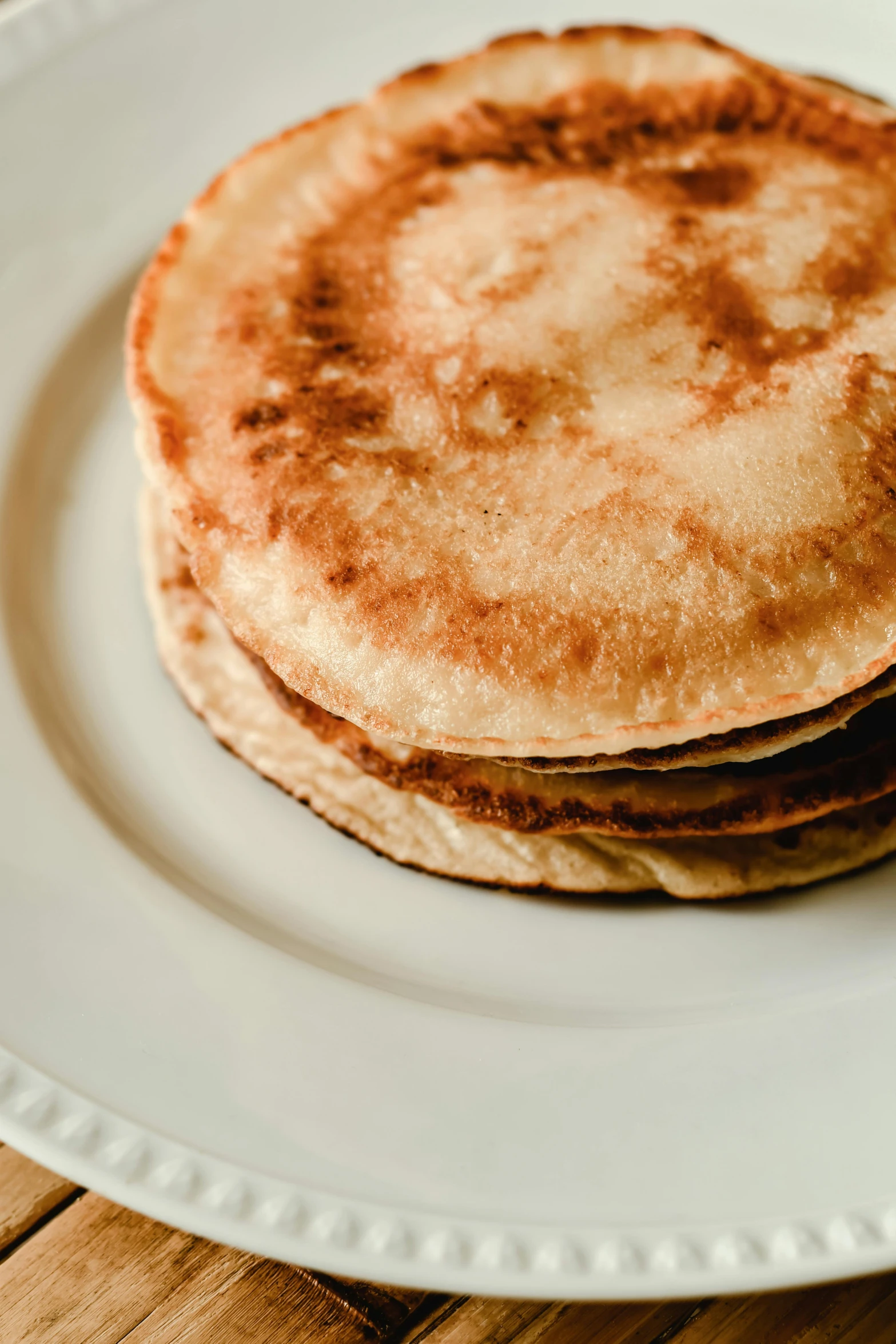 several homemade pancakes are stacked on a plate