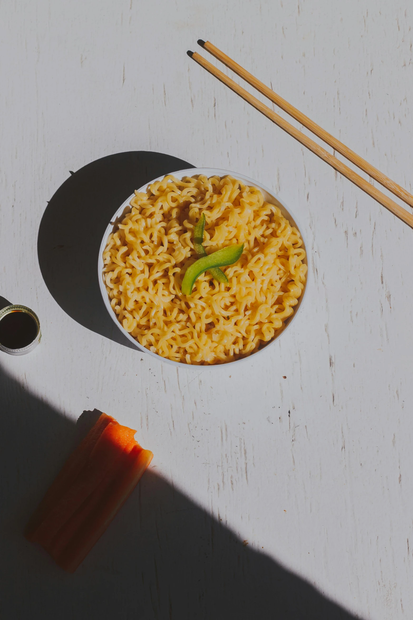 a bowl of noodles and chopsticks on a table, detailed product image, yellow orange, sunshine, reverse