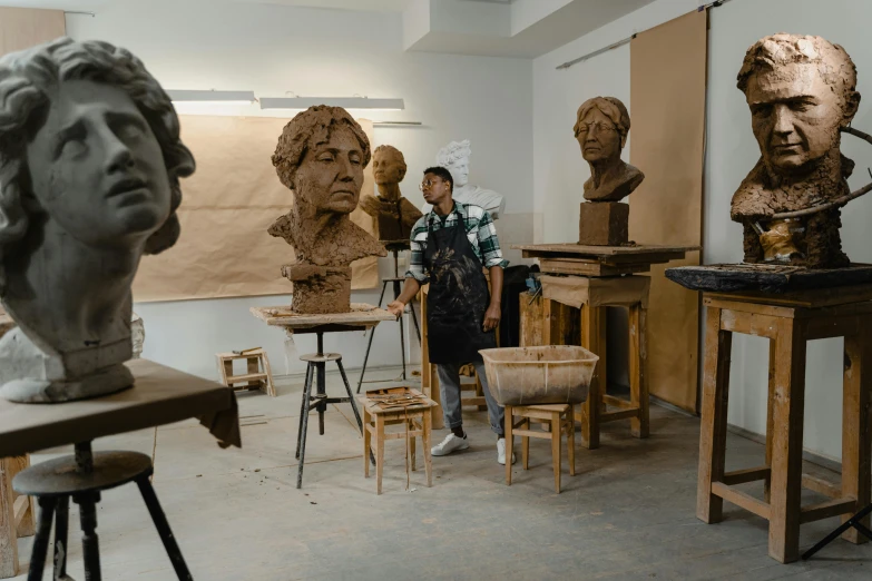 a man standing in front of a bunch of busts, a bronze sculpture, arbeitsrat für kunst, stands at her easel, darren quach, alexis franklin, life-size