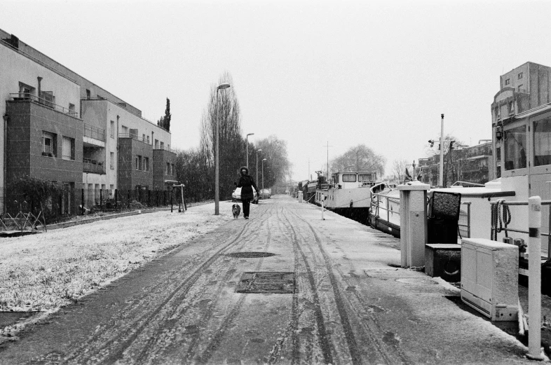 two people walking down a street in the snow