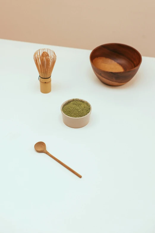 a white table topped with bowls and wooden utensils, inspired by Inshō Dōmoto, trending on unsplash, moringa juice, product display photograph, powder, close up portrait shot