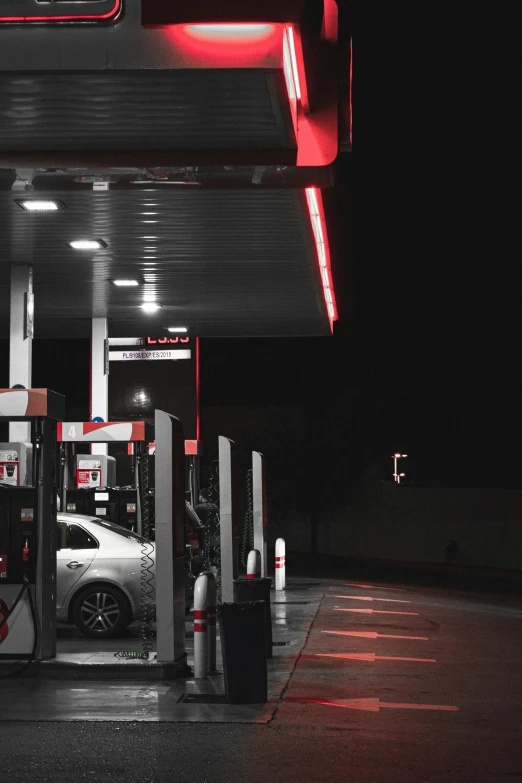 a red light shining on a gas station at night