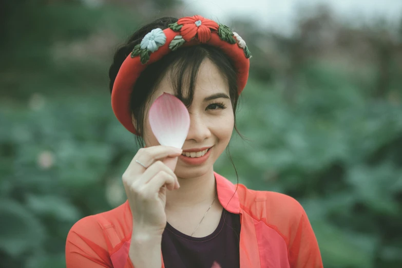 a woman holding a pink flower in front of her face, inspired by Tan Ting-pho, pexels contest winner, red headband, smiling confidently, avatar image, vietnamese woman