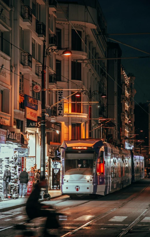 a street filled with lots of traffic next to tall buildings, by Niko Henrichon, pexels contest winner, art nouveau, trams ) ) ), night outside, istanbul, commercial banner