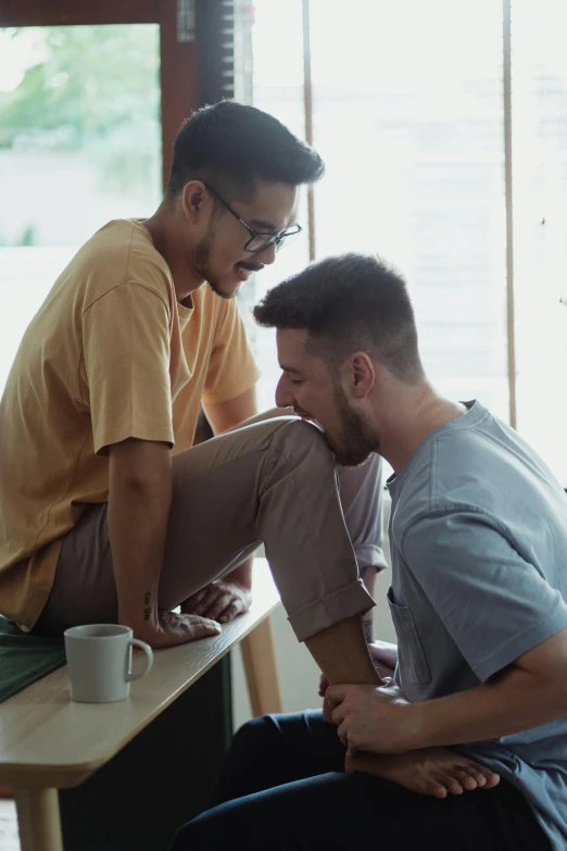 a couple of men sitting next to each other on a table, trending on pexels, lgbt, malaysian, compassion, giggling
