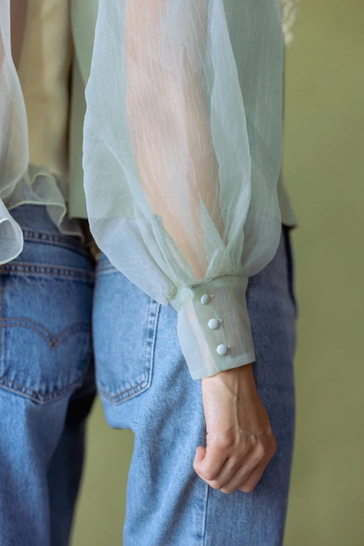 two people standing next to each other wearing jeans