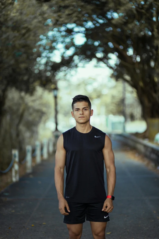 a man in black is standing on a road