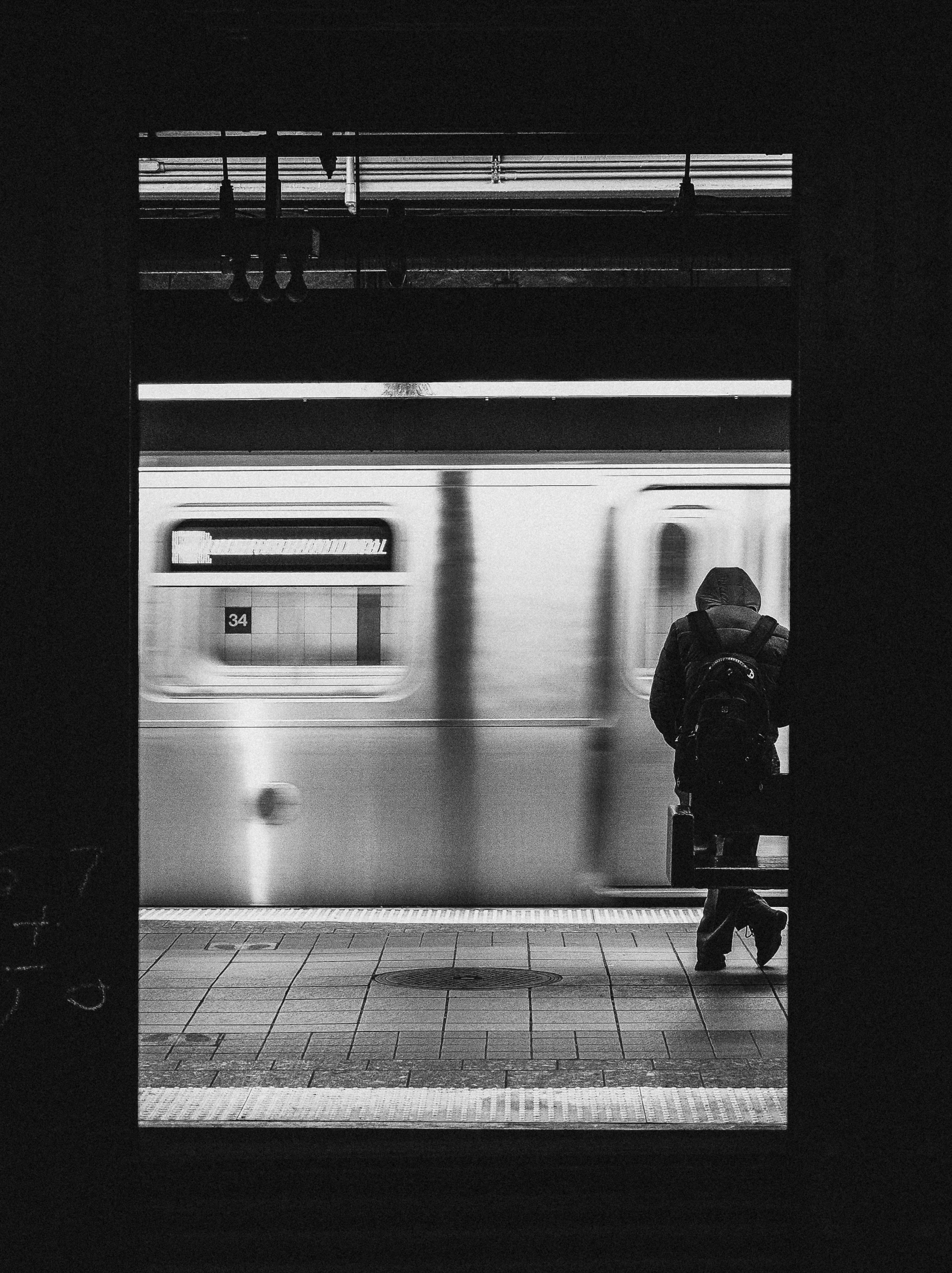 a person is standing with an umbrella at the subway platform