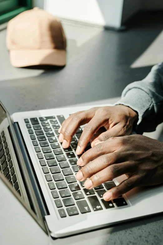 a close up of a person typing on a laptop, trending on pexels, grey, black man, multiple stories, university