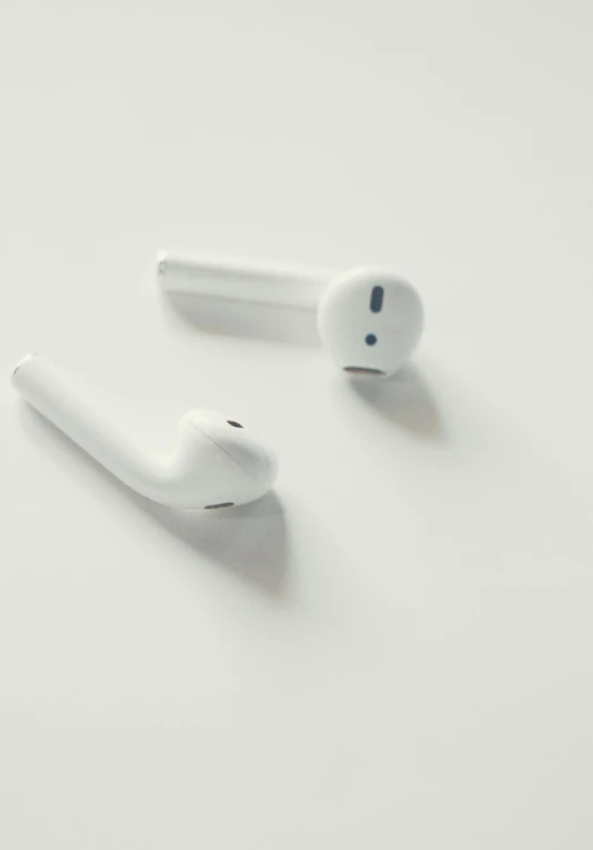 a pair of airpods sitting on top of a white surface, by Carey Morris, trending on pexels, square, wisps, in 2 0 1 5, made of glazed