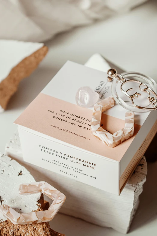 a close up of a box of soap on a table, a marble sculpture, inspired by Eden Box, private press, invitation card, diamond and rose quartz, clear curvy details, white clay