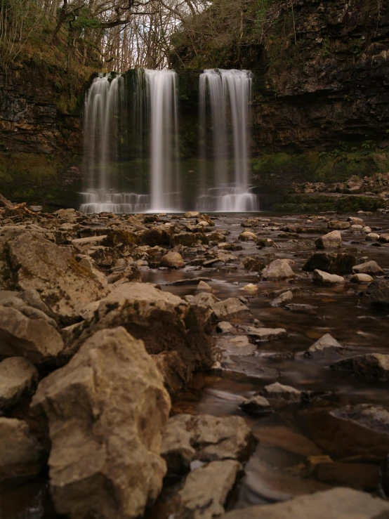 a waterfall flowing through a lush green forest, a picture, pexels contest winner, hurufiyya, with lots of dark grey rocks, marsden, night photo, detail shots