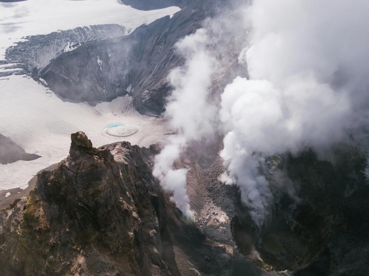 a small group of steam plumes billowing from the rocks