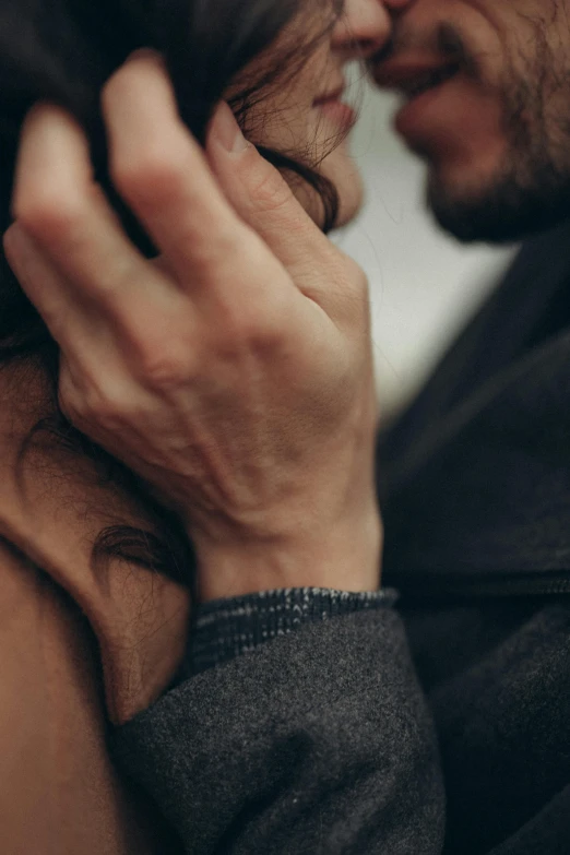 a close up of a person kissing a woman, trending on pexels, with his hands in his hair, closeup of arms, lightly dressed, dark. no text