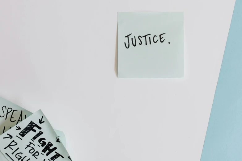 a piece of paper with the words justice written on it, by Jessie Algie, trending on pexels, whiteboards, heroic figure, protest, sustainable