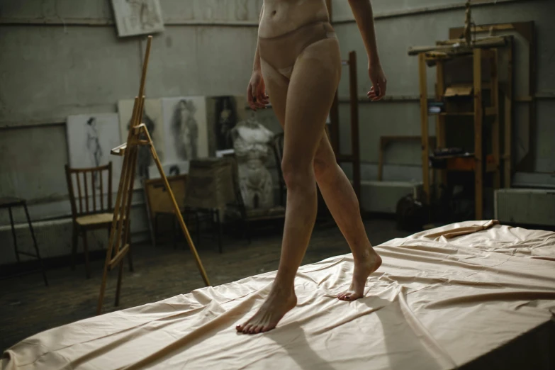 a woman standing on a sheet in a room, inspired by Vanessa Beecroft, unsplash, hyperrealism, two legs, still from film, in her art room, a woman walking